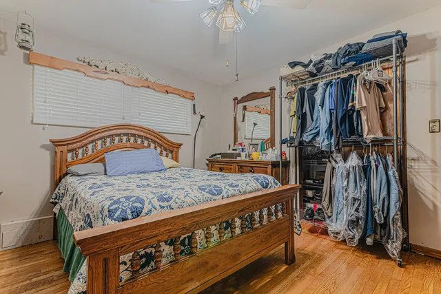 a bedroom with a bed a dresser and cabinets