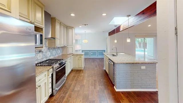 a kitchen with stainless steel appliances granite countertop wooden floors and stove