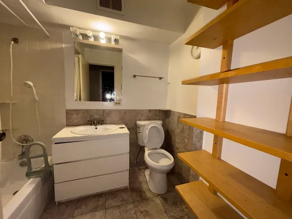 a bathroom with a sink a toilet and mirror