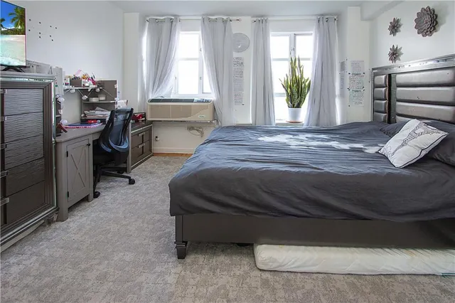 a bedroom with a bed dresser and a window