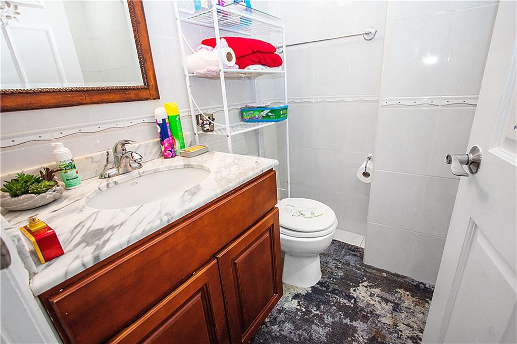 1720 East 14th Street, Unit 4A Brooklyn, NY 11229 - Photo 6 of 13 a bathroom with a sink vanity mirror and toilet