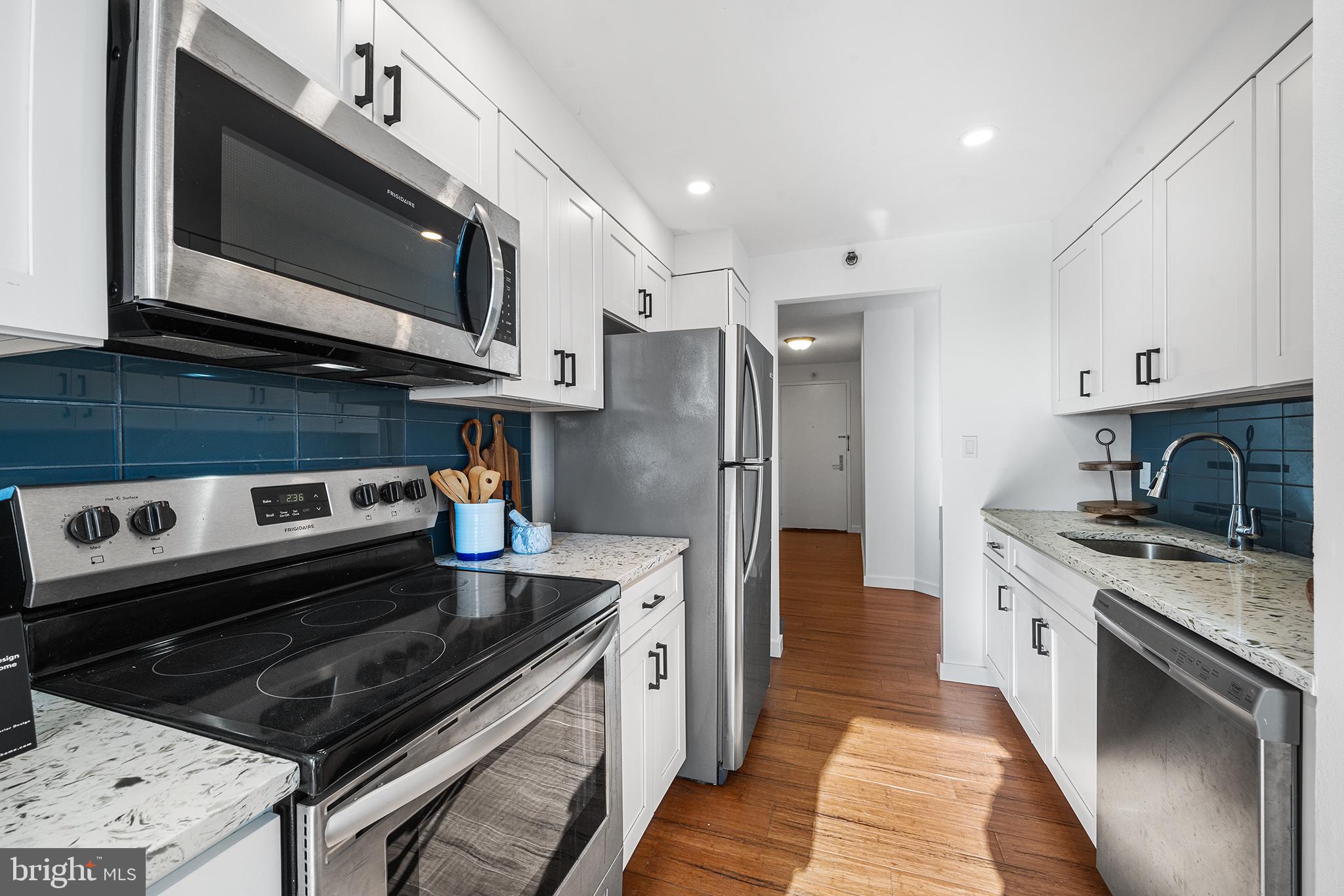 2018 Walnut Street, Unit 16E Philadelphia, PA 19103 - Photo 14 of 35 a kitchen with stainless steel appliances granite countertop a stove microwave and refrigerator