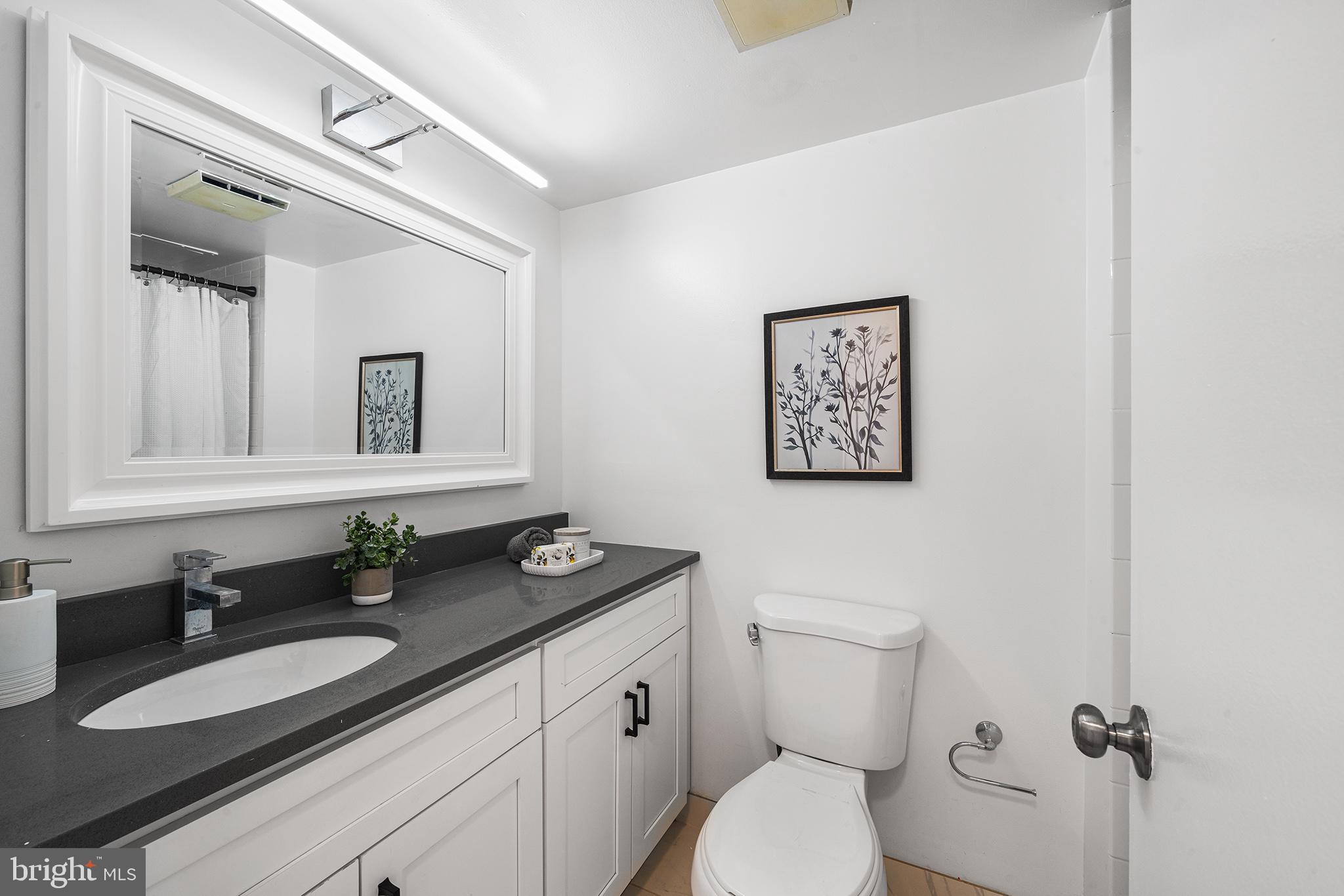 2018 Walnut Street, Unit 16E Philadelphia, PA 19103 - Photo 18 of 35 a bathroom with a granite countertop toilet sink and mirror