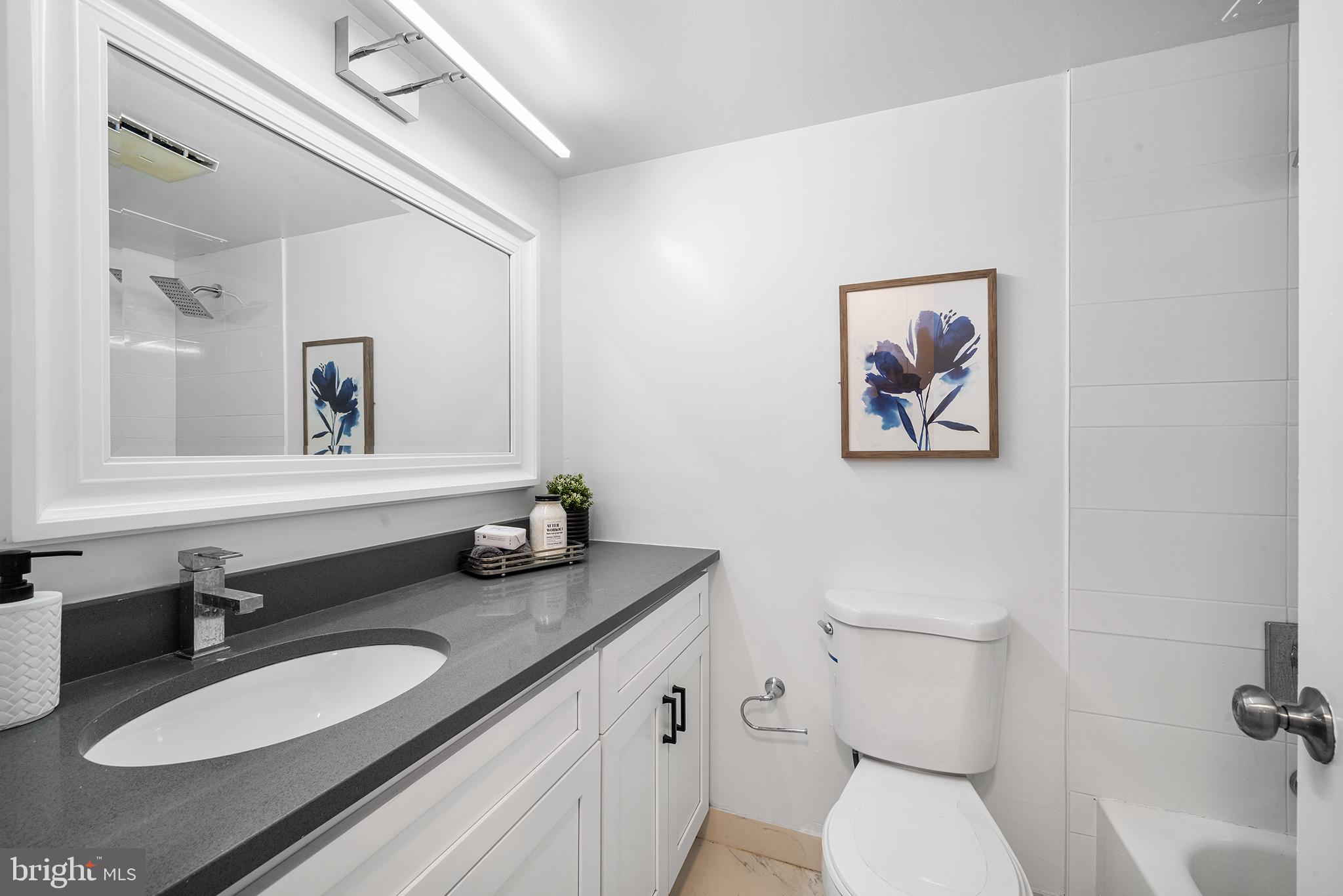 2018 Walnut Street, Unit 16E Philadelphia, PA 19103 - Photo 23 of 35 a bathroom with a granite countertop sink mirror and toilet
