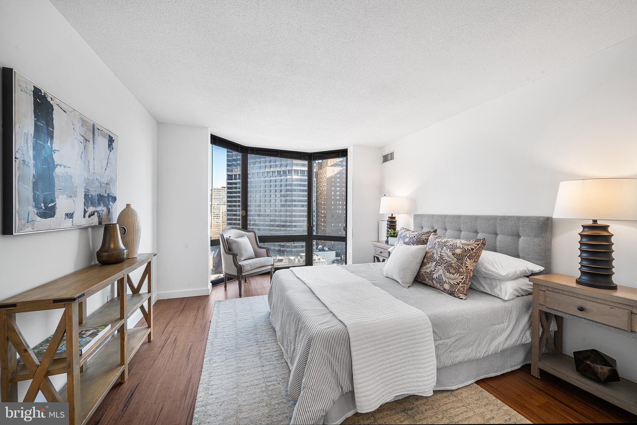 2018 Walnut Street, Unit 16E Philadelphia, PA 19103 - Photo 24 of 35 a bedroom with a bed a bookshelf a desk and chair with the wooden floor