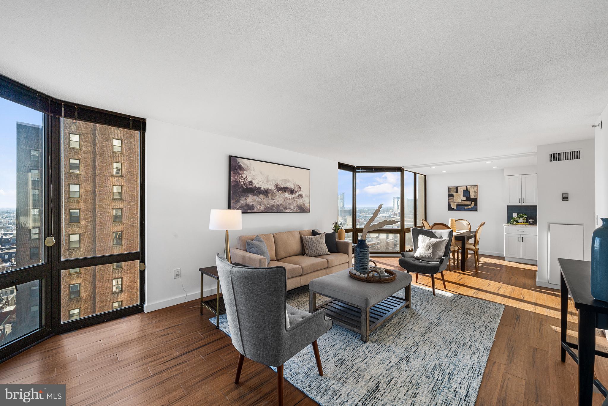 2018 Walnut Street, Unit 16E Philadelphia, PA 19103 - Photo 6 of 35 a living room with furniture and a floor to ceiling window next to a large window