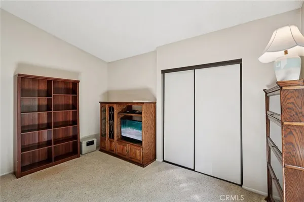 a view of an empty room with cabinet and window