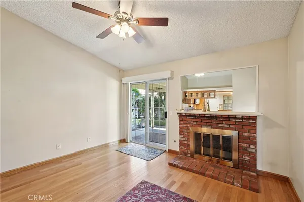 a living room with wooden floor and a fireplace