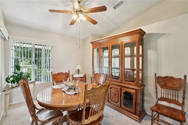 a dining room with furniture a chandelier and wooden floor
