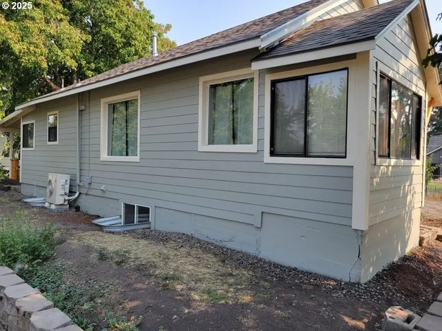 a view of a backyard with table and chairs and floor to ceiling window