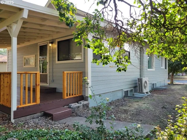 a view of a house with backyard and trees