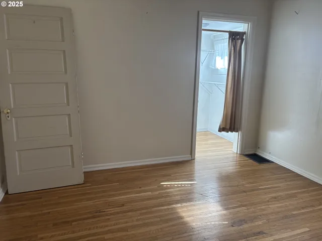 an empty room with wooden floor and closet