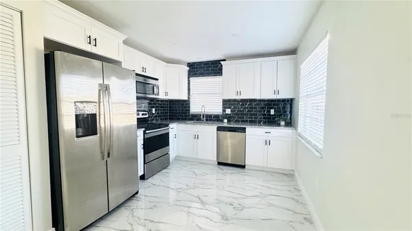 a kitchen with cabinets and stainless steel appliances