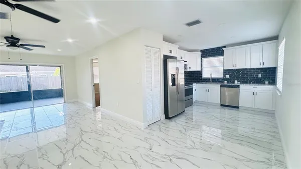 a kitchen with stainless steel appliances granite countertop a refrigerator and a stove top oven