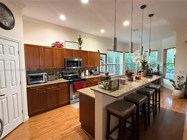 a kitchen with kitchen island granite countertop a sink counter and chairs