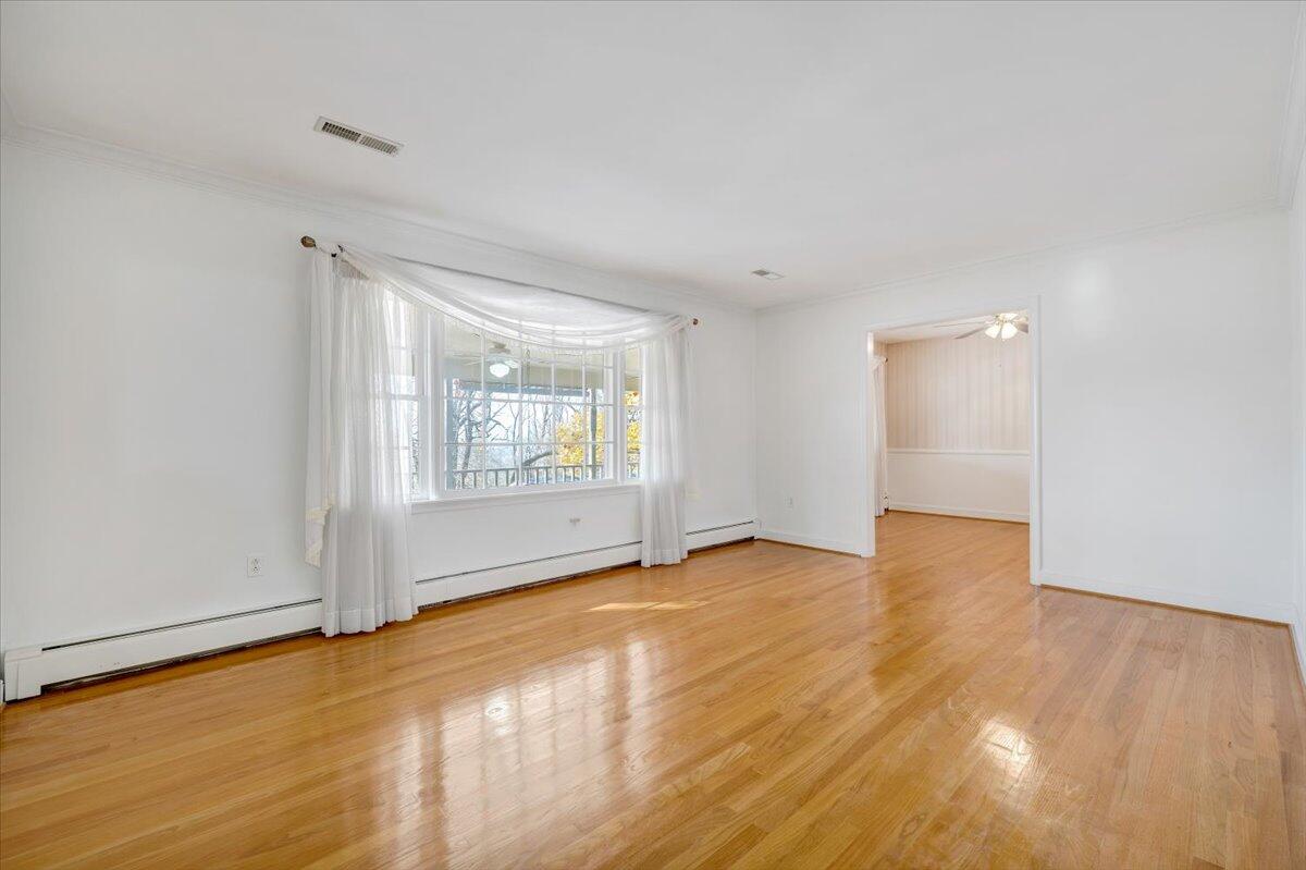 709 Olney Road Vinton, VA 24179 - Photo 12 of 41 an empty room with wooden floor and windows