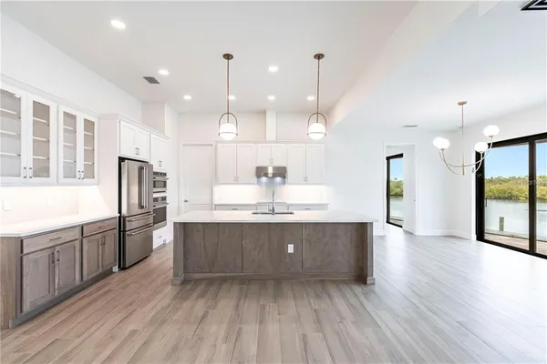 a view of a kitchen with a refrigerator a sink and wooden floor
