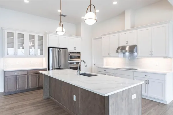 a kitchen with stainless steel appliances kitchen island granite countertop a refrigerator and microwave
