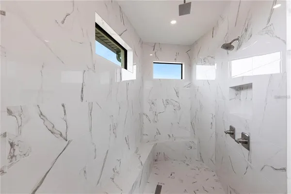 an empty room with windows and ceiling fan
