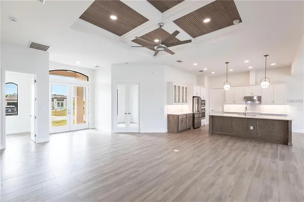 a large room with stainless steel appliances kitchen island wooden floors and view living room