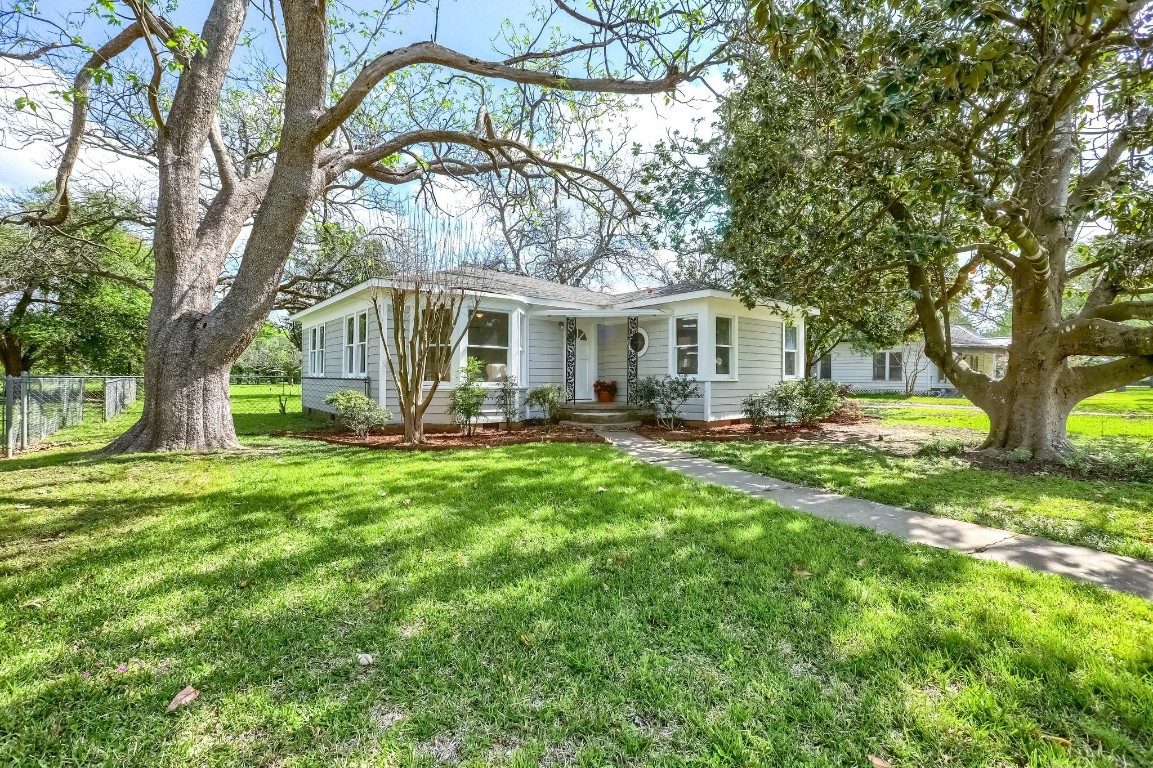a front view of a house with yard and green space