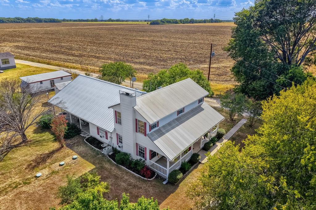 626 Epps Road Palmer, TX 75152 - Photo 40 of 40 Property featuring a metal roof, white exterior siding, red window shutters, a prominent chimney, and a covered porch