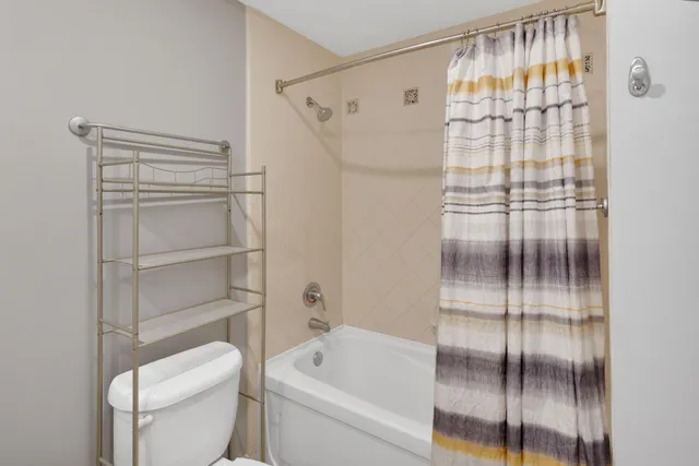 a bathroom with a shower a toilet and a sink