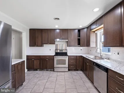 a kitchen with a sink a stove top oven and refrigerator