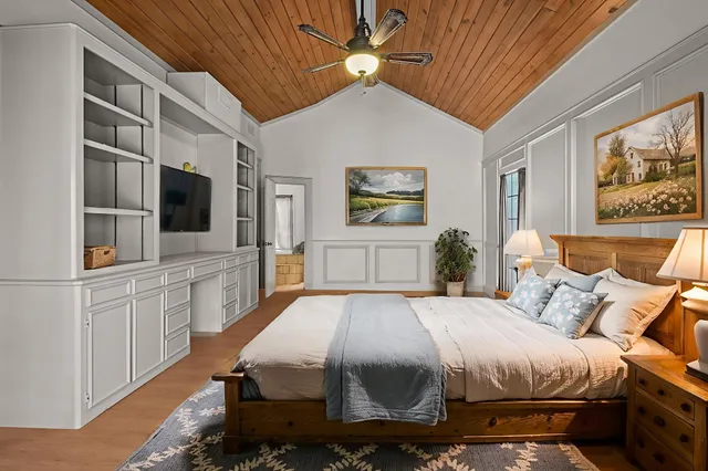 a spacious bedroom with a bed and a flat screen tv