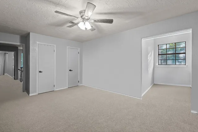 a view of staircase with railing and a chandelier fan