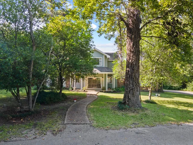a front view of a house with a yard and trees