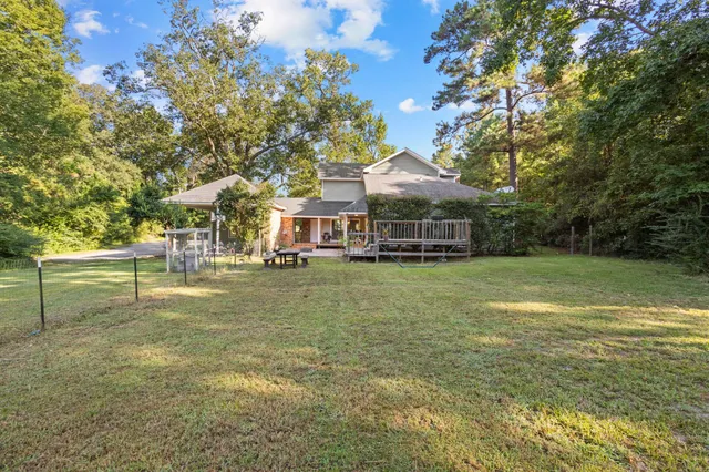 a view of a house with pool and chairs in patio