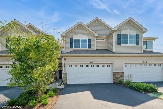 a view of a house with a yard and potted plants