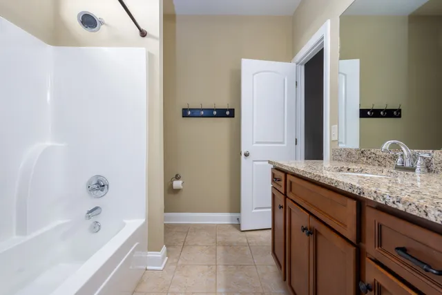 a bathroom with a granite countertop toilet a sink and a bathtub