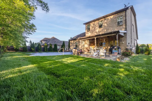 a view of a swimming pool with lawn chairs potted plants