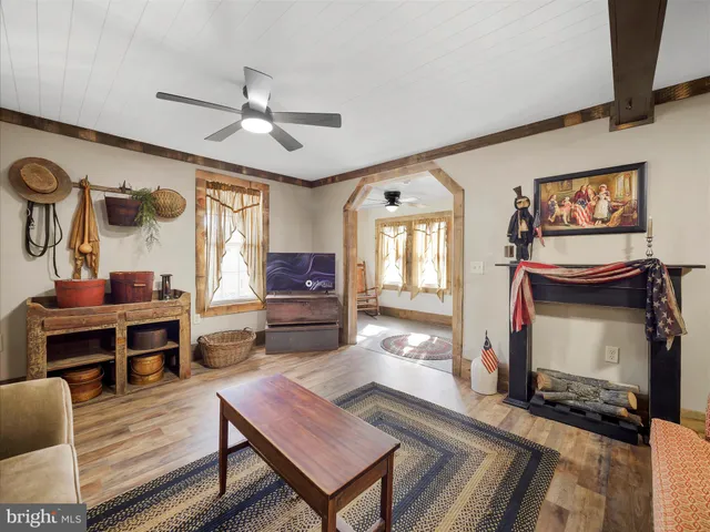 a living room with furniture a flat screen tv and kitchen view
