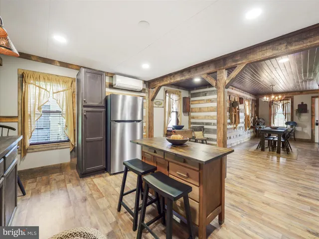 a room with stainless steel appliances kitchen island granite countertop furniture and a wooden floor