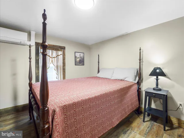 a bedroom with a bed wooden floor and a window