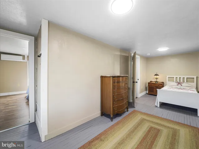 a living room with furniture and a refrigerator