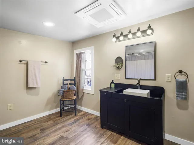 a bathroom with a sink vanity and mirror