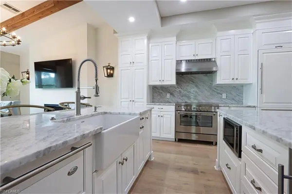 a kitchen with stainless steel appliances granite countertop a sink stove and cabinets