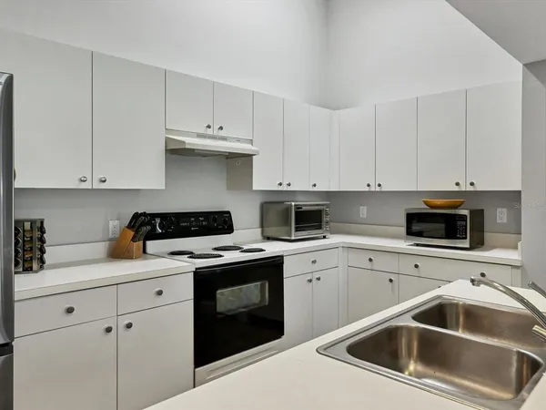 a kitchen with white cabinets and white appliances