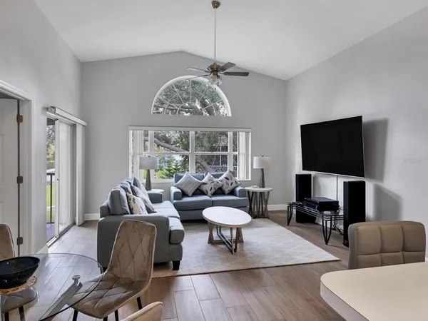 a living room with furniture a chandelier and a flat screen tv