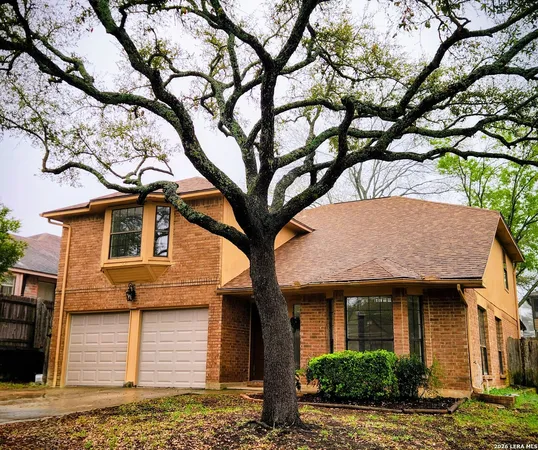 a front view of a house with a tree