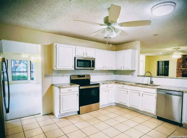 a kitchen with stainless steel appliances kitchen island granite countertop a sink and cabinets