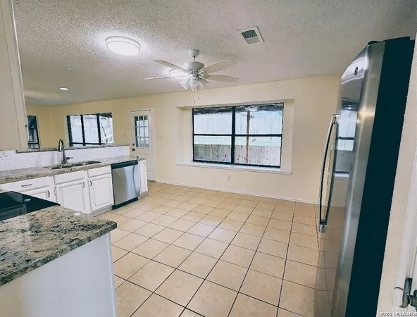 a kitchen with stainless steel appliances granite countertop a refrigerator sink and cabinets