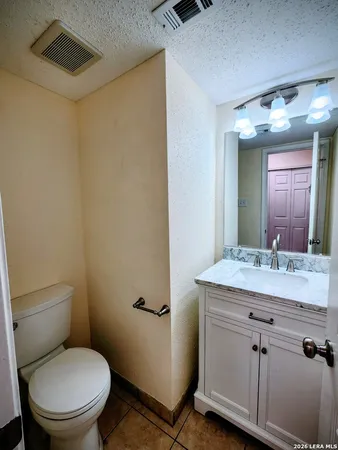 a bathroom with a granite countertop toilet sink and mirror