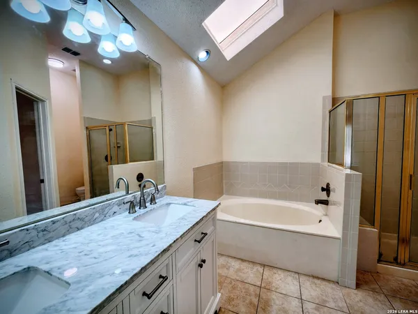 a bathroom with a granite countertop sink a large mirror and a bathtub