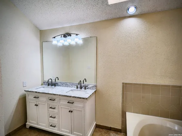 a bathroom with a sink vanity and a mirror