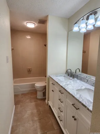 a white toilet and tub sitting next to a bathroom sink
